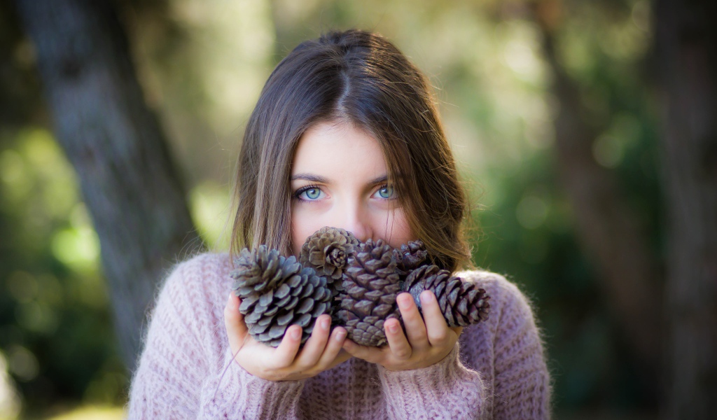 Молодая девушка с шишками в руках