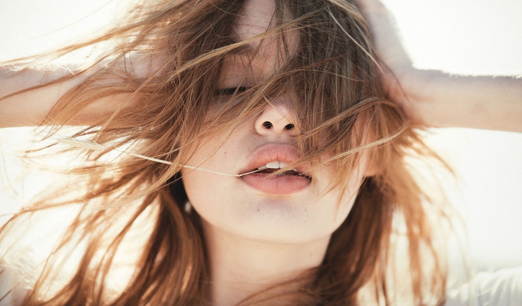 Молодая девушка с распущенными волосами на ветру