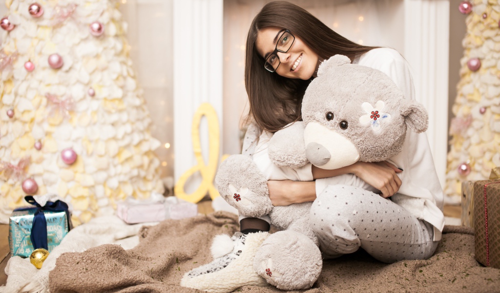 Молодая девушка в очках с плюшевым мишкой