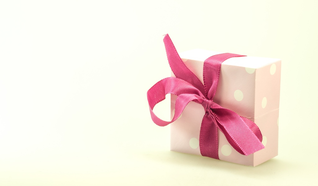 Подарочная коробка с розовым бантом на белом фоне