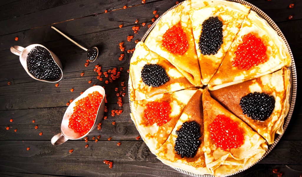 Блины с черной и красной икрой на деревянном столе на Масленицу