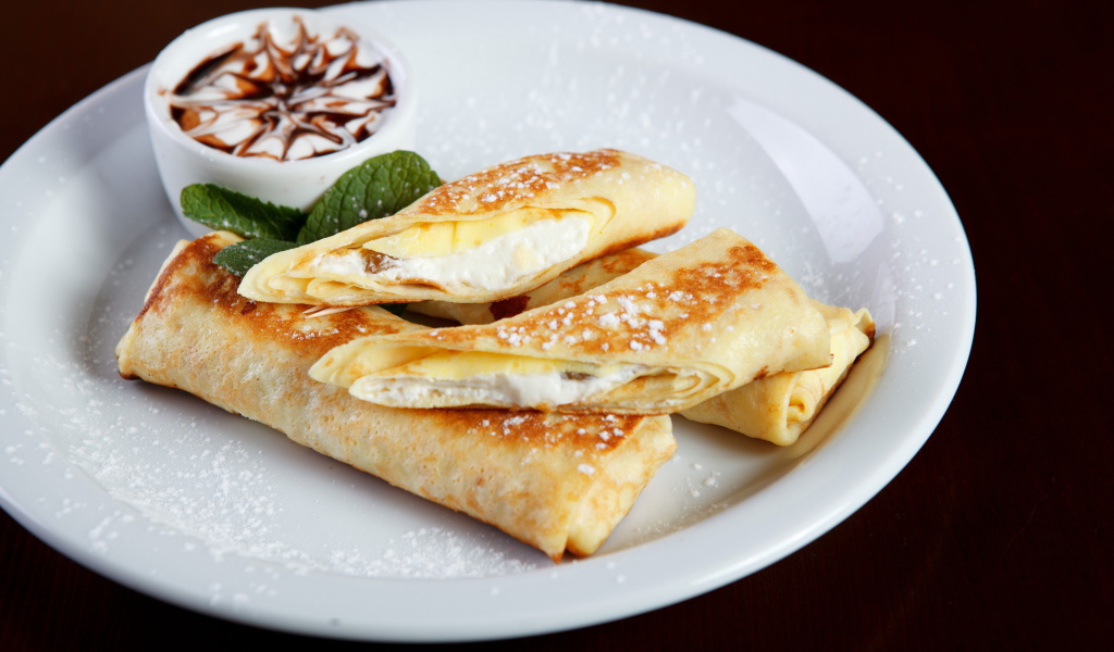 Блины с творогом и сметаной на белой тарелке на Масленицу