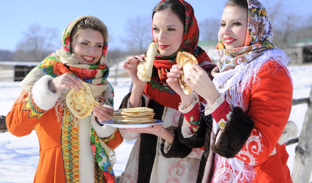 Три молодые красивые девушки с блинами на Масленицу