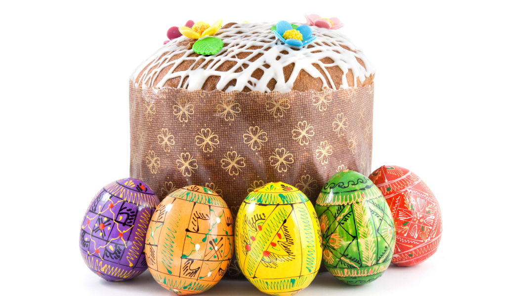 Пасхальный кулич с расписанными яйцами на белом фоне