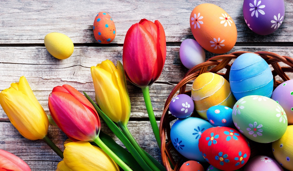 Крашеные яйца на столе с тюльпанами на Пасху