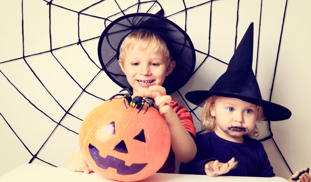 Маленькие мальчик и девочка в костюмах на Хэллоуин