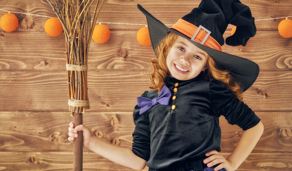 Маленькая девочка в костюме ведьмы на праздник Хэллоуин