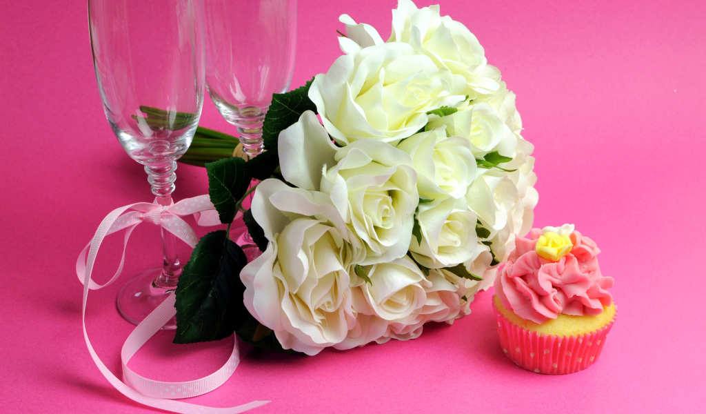 Букет белых роз, пирожное и два бокала на розовом фоне на 8 марта