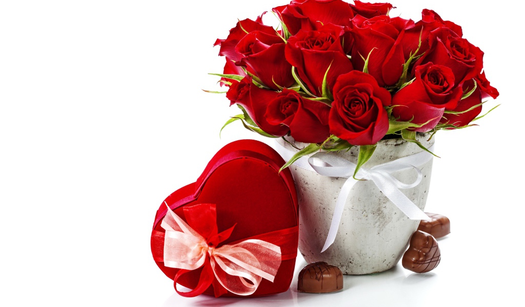 Коробка с конфетами в форме сердца и букет красных роз на белом фоне на День Влюбленных 14 февраля
