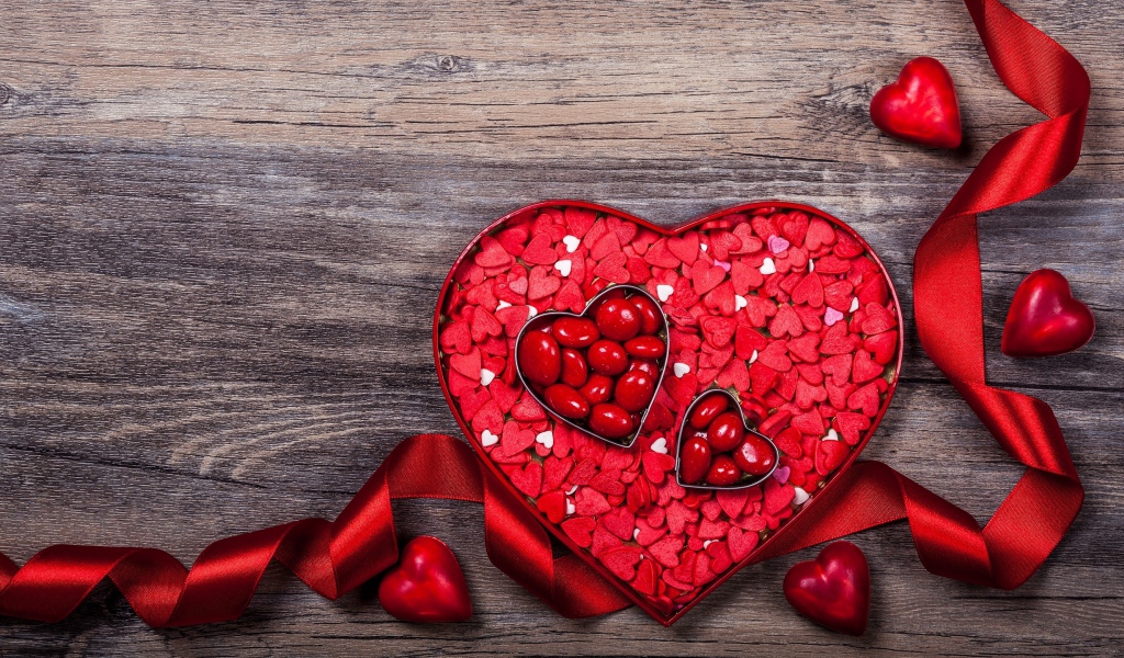 Коробка конфет в форме сердца с красной лентой в подарок