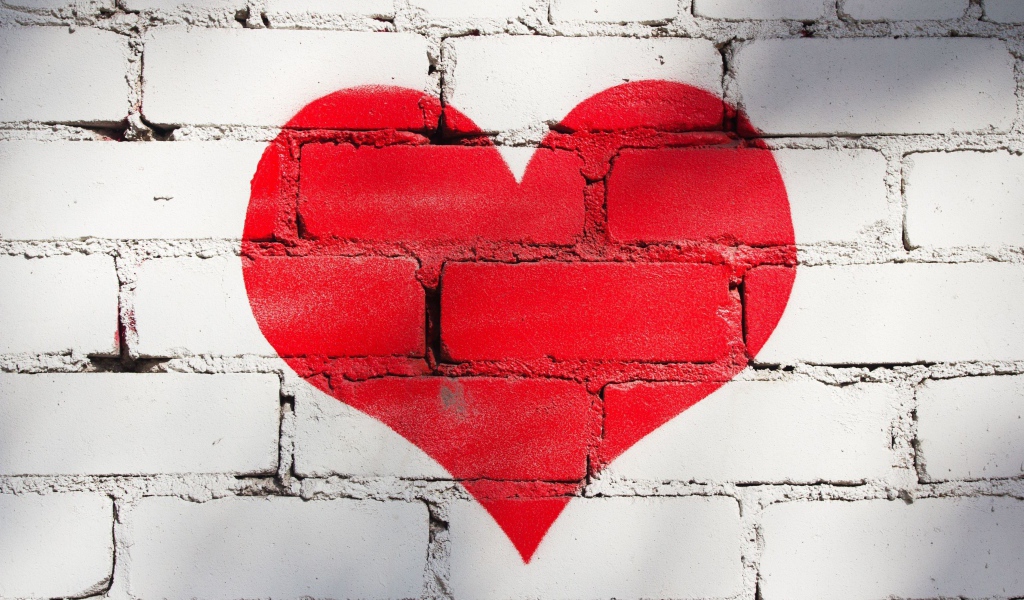Большое красное сердце нарисовано на кирпичной стене