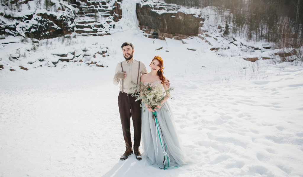 Влюбленная пара молодоженов стоит на снегу