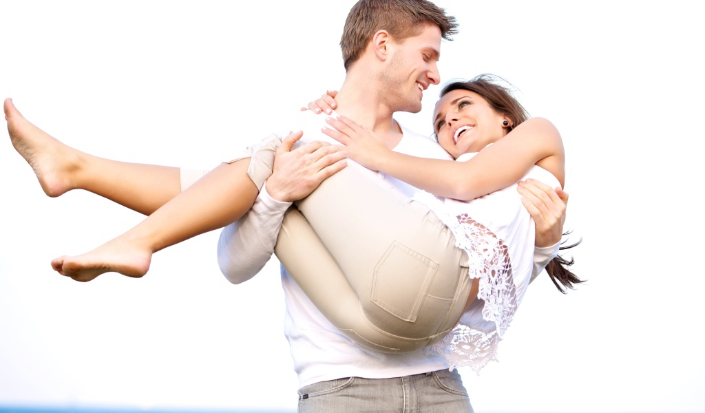 Влюбленный парень держит девушку на руках