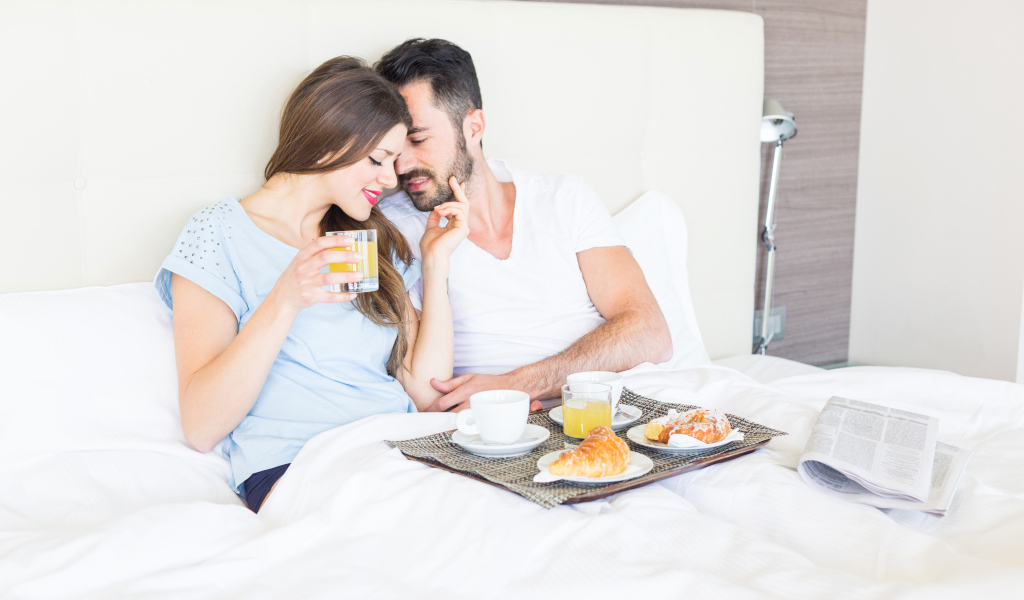 Влюбленная пара с завтраком в постели