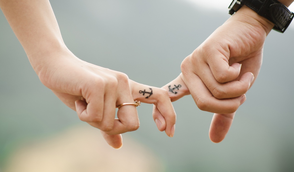Руки влюбленной пары с татуировками на руках 