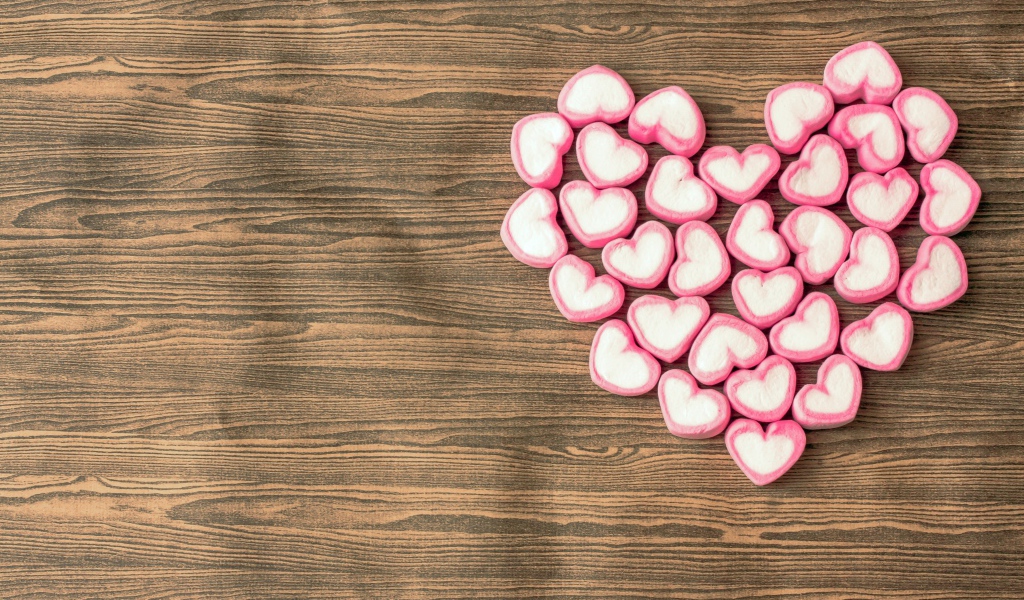 Сердце из конфет в форме сердца на деревянном столе