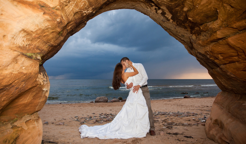 Поцелуй жениха и невесты на фоне моря