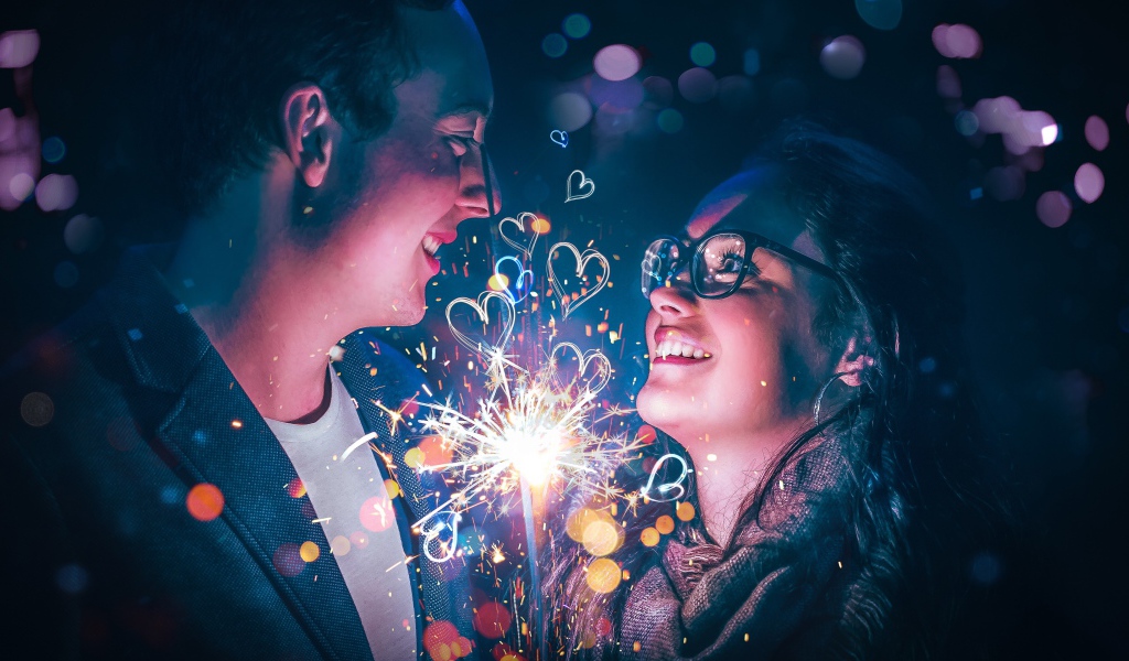 Влюбленные парень и девушка с бенгальским огнем в руке