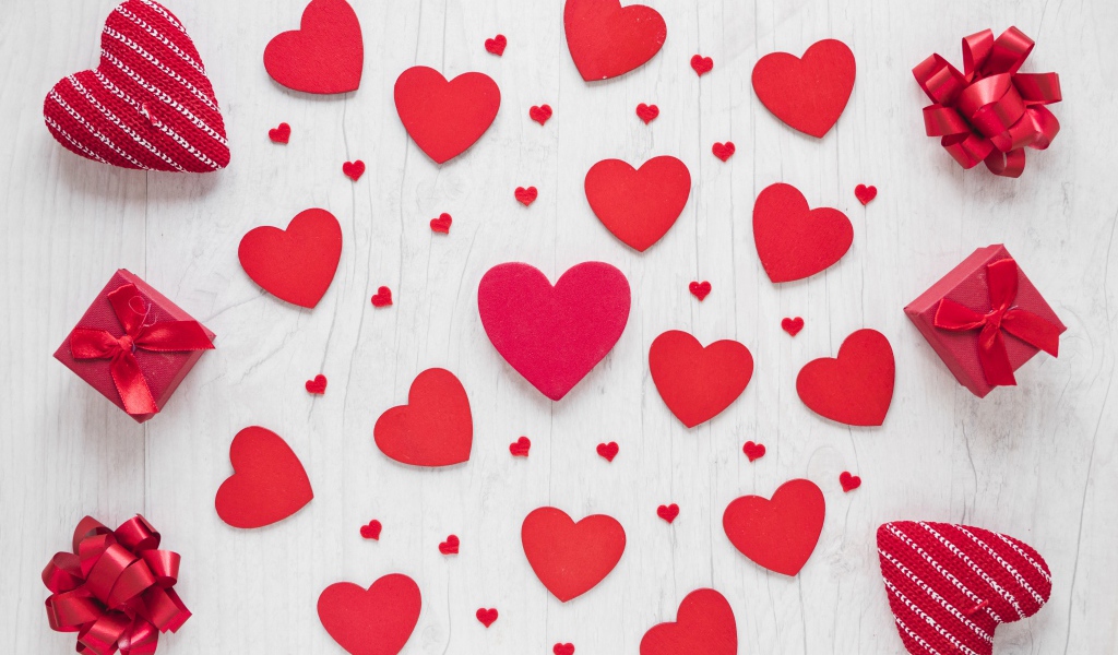 Много красных сердечек на столе с подарками 
