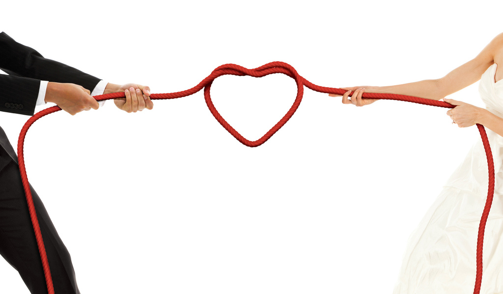 Newlyweds pull a rope with a heart on a white background