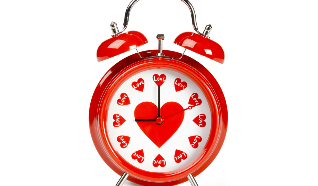 Красный будильник с сердечками на белом фоне