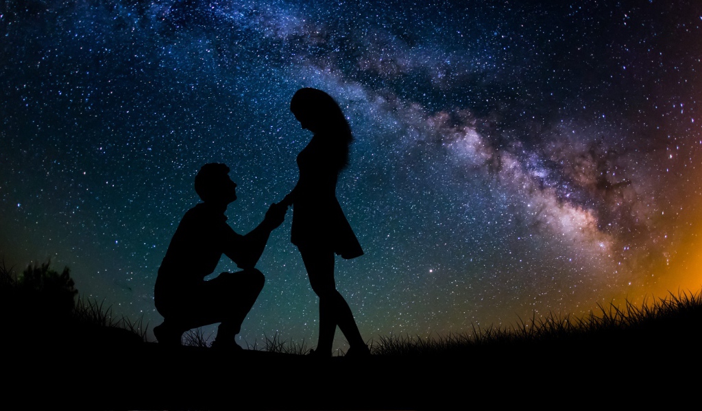 Силуэты влюбленной пары на фоне звездного неба ночью 