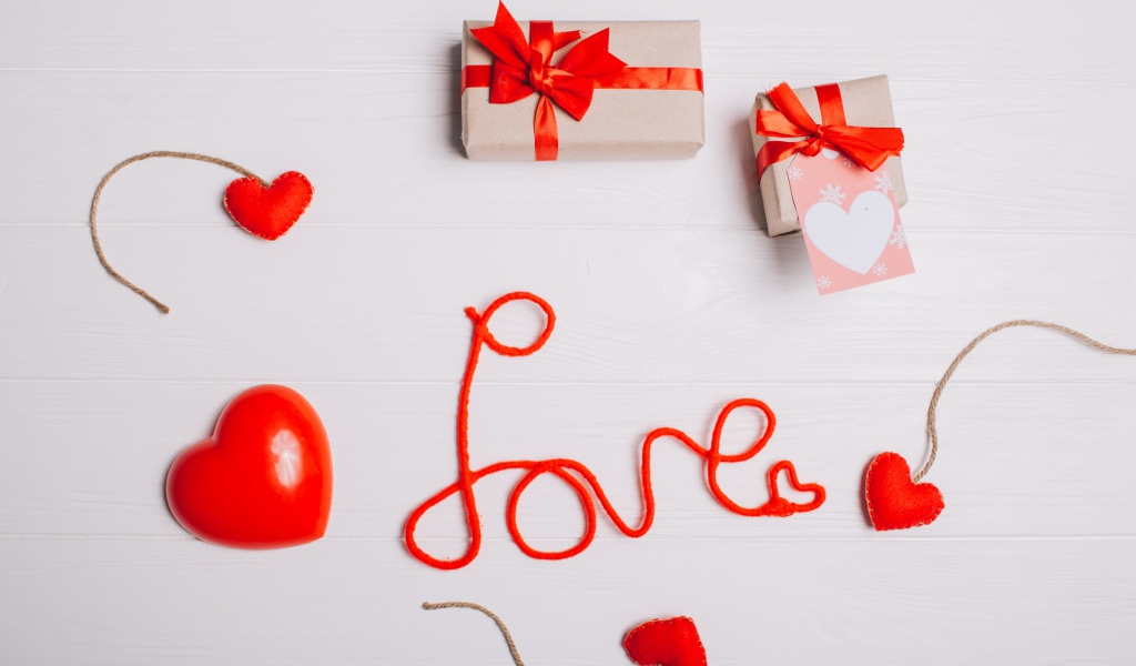 Надпись любовь красными нитями на сером фоне с сердечками и подарками