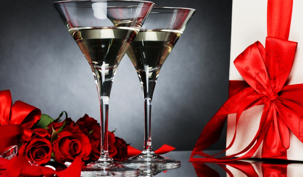 Два бокала с мартини, подарком и красными розами для любимой