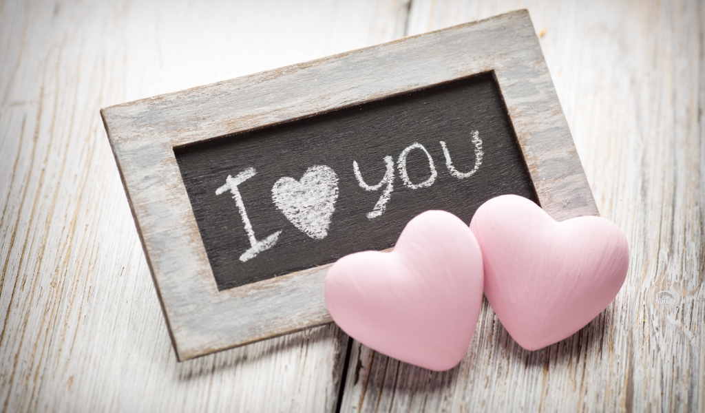 Два розовых сердца на столе с деревянной рамкой