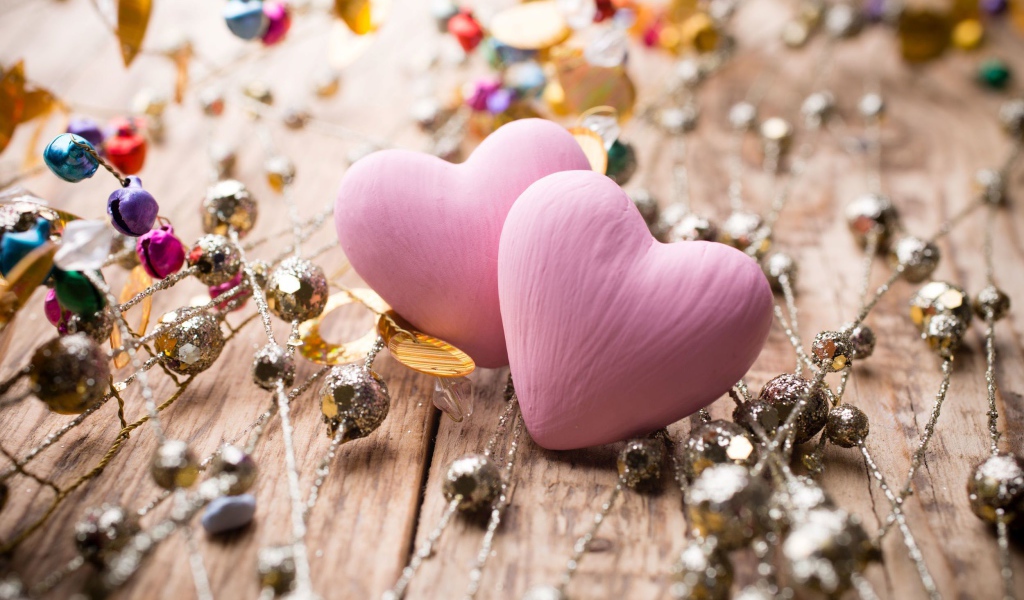 Два розовых сердца на деревянном фоне с элементами декора