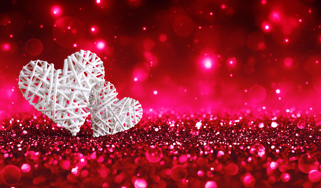 Два белых плетеных сердца на мерцающем красном фоне