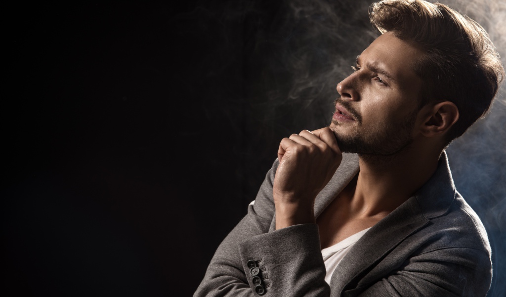 Красивый задумчивый мужчина в сером пиджаке