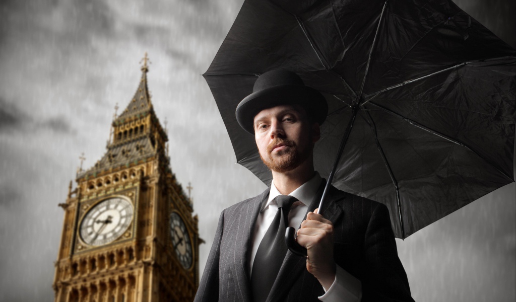 Мужчина в костюме с черным зонтом у башни с часами 