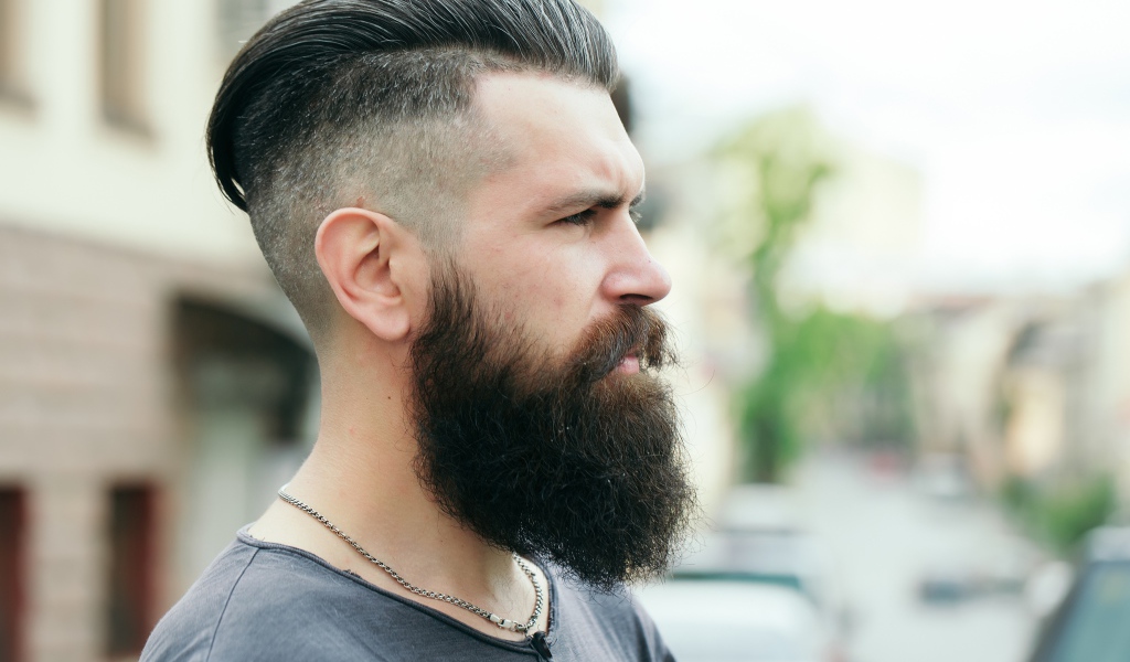 Стильный мужчина с бородой и прической на голове 