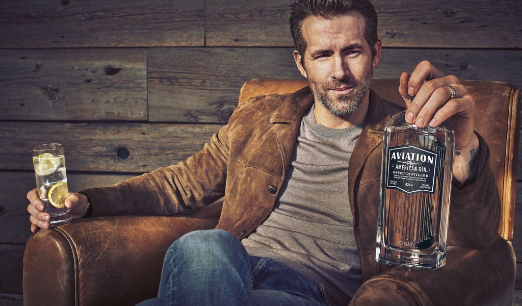 Актер Райан Рейнольдс в кресле с бутылкой в руке