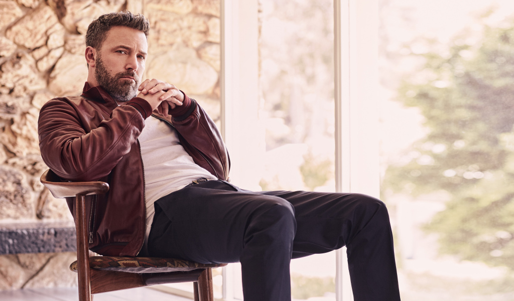 Популярный актер Бен Аффлек сидит на стуле