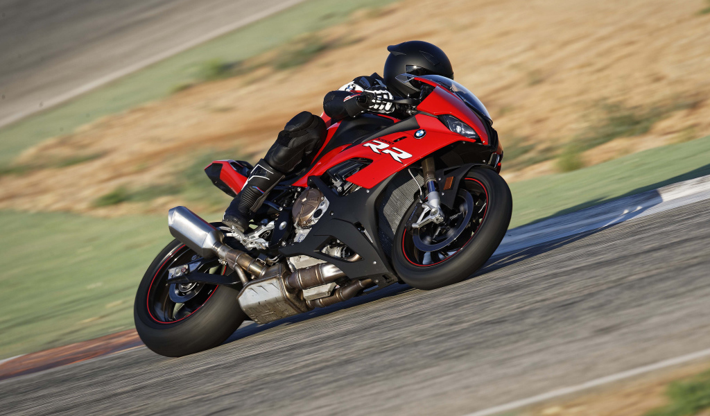 Гонщик на мотоцикле BMW S1000 совершает крутой поворот