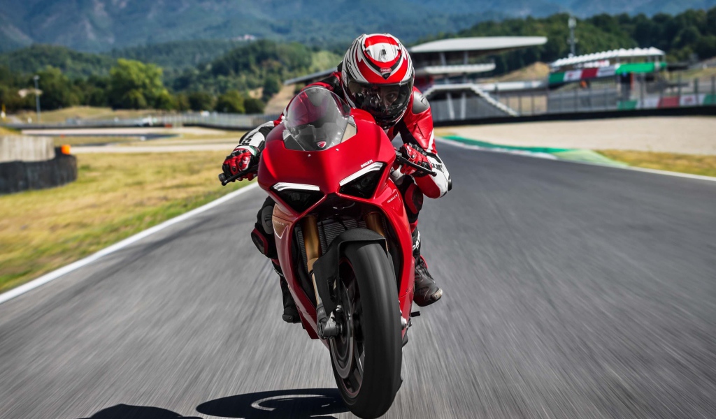 Красный мотоцикл  Ducati Panigale V4 S, 2018 на трассе с мотогонщиком