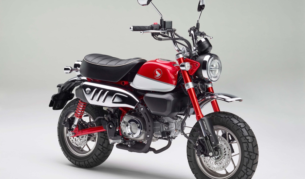 Красный мотоцикл Honda Monkey, 2018 года на сером фоне