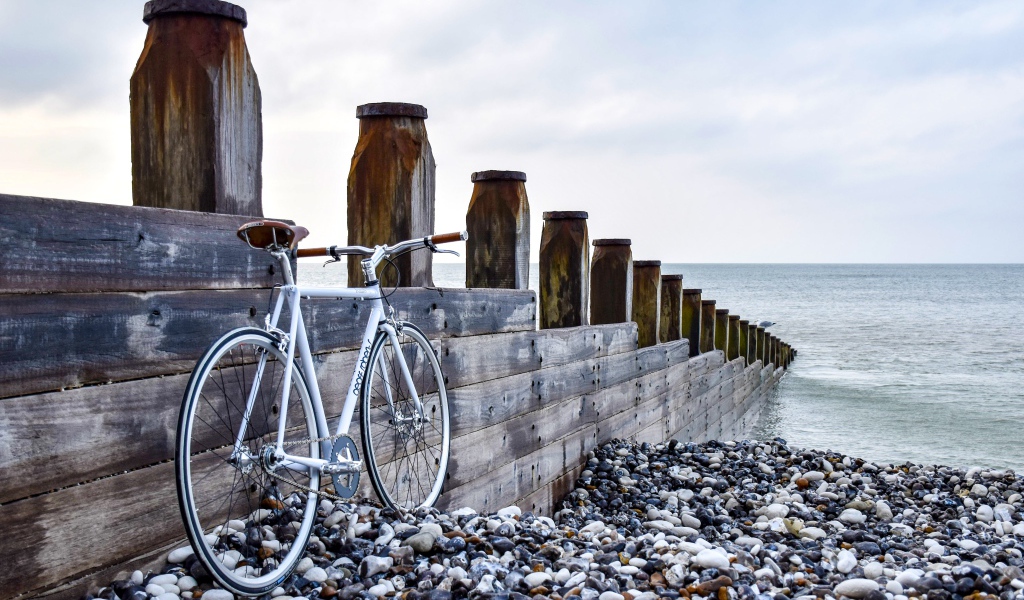 Велосипед стоит и моста на берегу моря