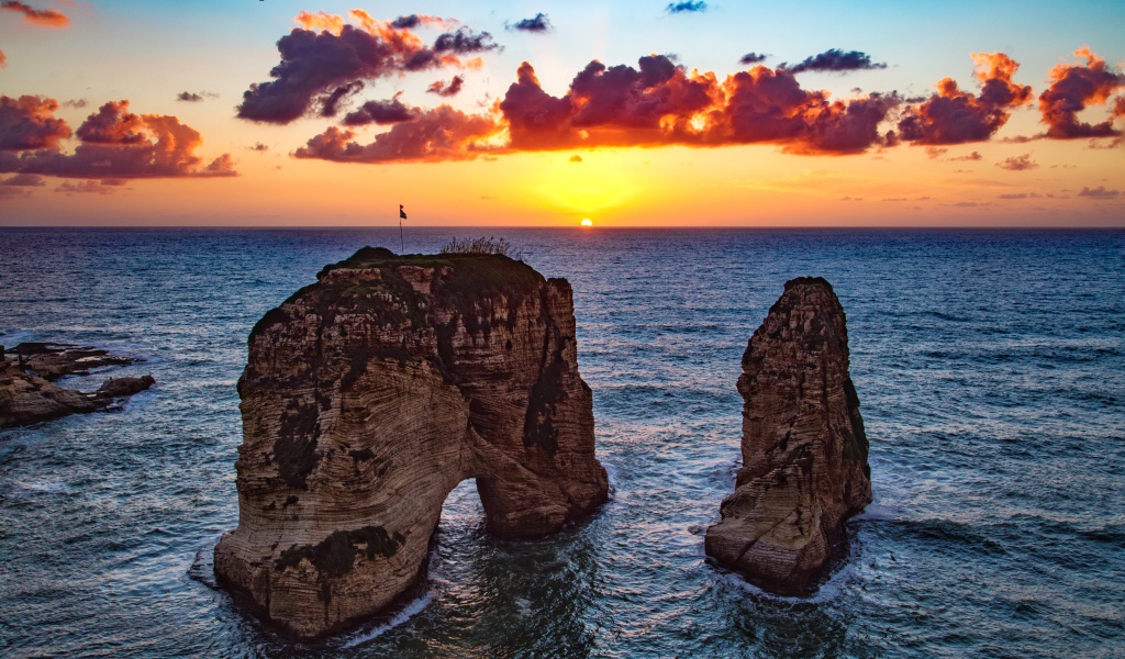 Арка скала в море на закате солнца
