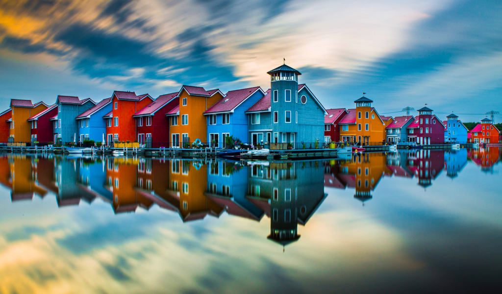 Красивые разноцветные дома отражаются в воде под красивым небом