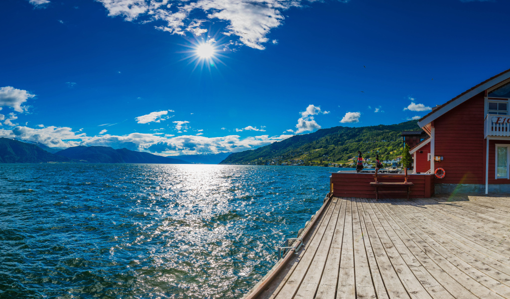 Яркое солнце в голубом небе над водой, Исландия