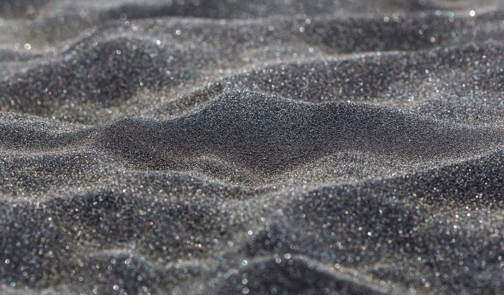 Блестящий черный песок крупным планом