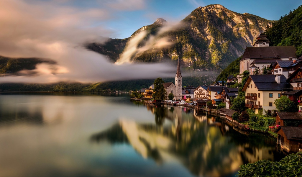 Город Гальштат над туманным озером в горах Альпы, Австрия