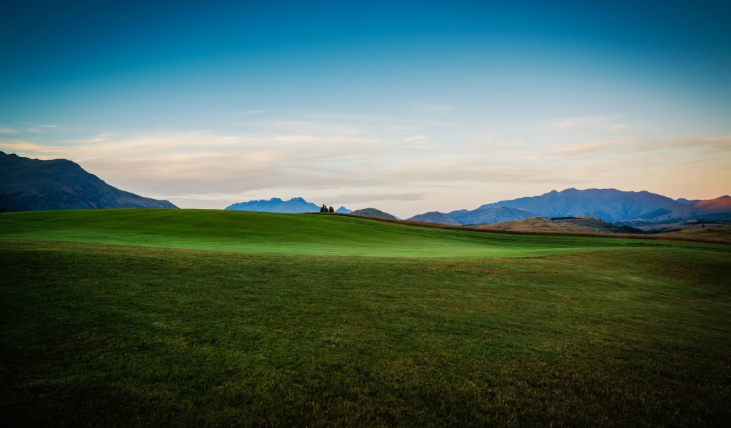 Зеленый луг на фоне красивого неба