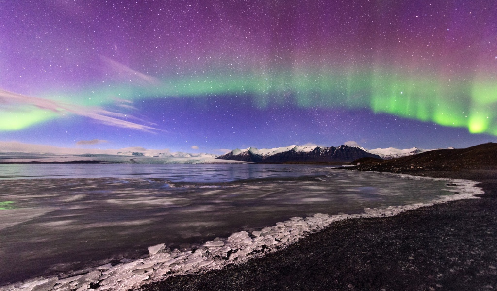 Северное сияние в небе над покрытым льдом озером 