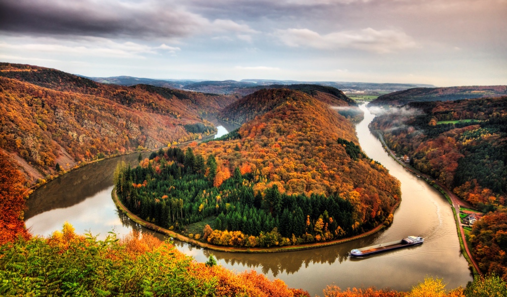 Река рядом с осенним лесом на фоне пасмурного неба