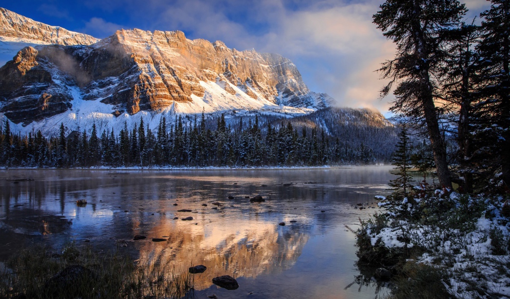 Покрытые снегом горы у заледеневшего озера