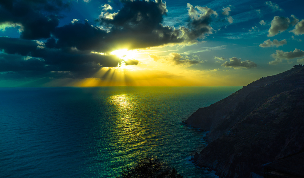 Лучи солнца пробиваются сквозь облака над океаном